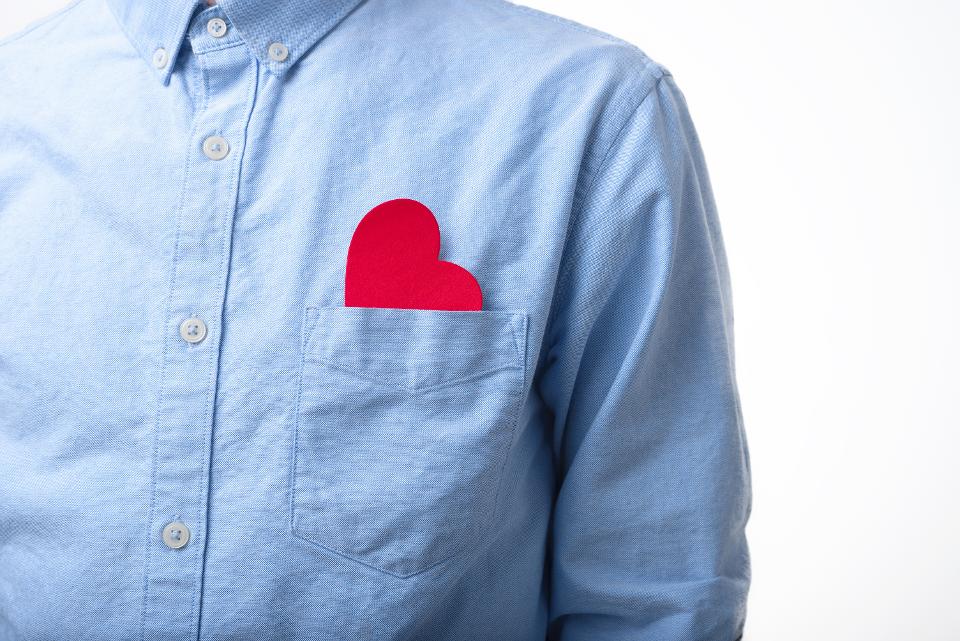 Heart shape in a pocket of a blue shirt. Love, alone, single, in love concept.