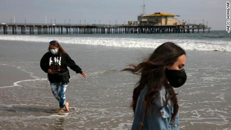 A mother and daughter  wear masks as they visit the beach Tuesday in Santa Monica, Calif. 