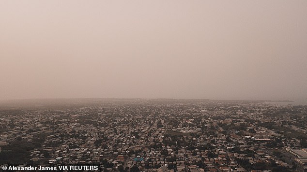 The dust cloud is seen over the city of Bridgetown, Barbados, Monday