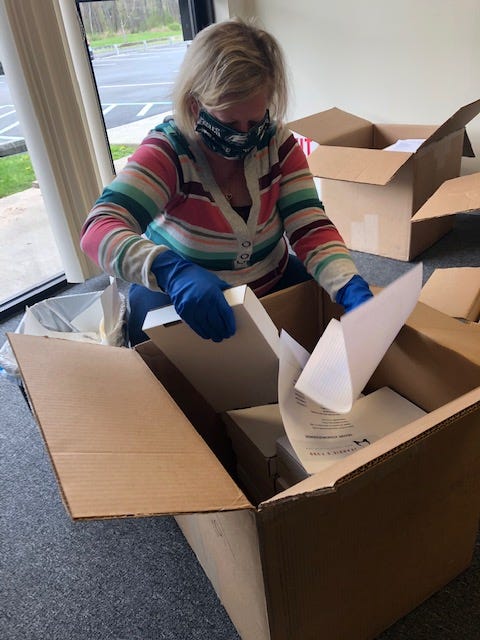 A volunteer with Jeannie's Fund unpacking purchased iPads. Volunteers clean, test and label the devices before they go out to hospitals or other facilities.