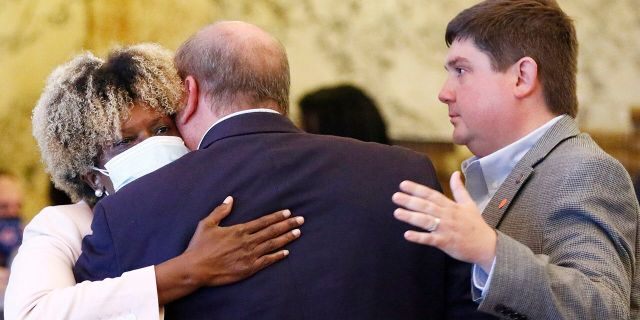 Mississippi state Sen. Sarita Simmons, D-Cleveland, left, hugs Republican Sen. Brice Wiggins, of Pascagoula, center, and Jeremy England, of Vancleave, following the body passing a resolution that would allow lawmakers to change the state flag Saturday, June 27, 2020, at the Capitol in Jackson, Miss. (Associated Press)