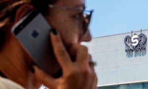 An Israeli woman uses her iPhone in front of the building housing the Israeli NSO Group in Herzliya, near Tel Aviv.