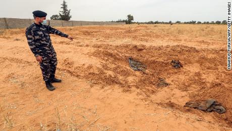 A member of security forces affiliated with the Libyan Government of National Accord (GNA)&#39;s Interior Ministry points at the reported site of a mass grave in the town of Tarhuna, about 65 kilometres southeast of the capital Tripoli on June 11, 2020. 