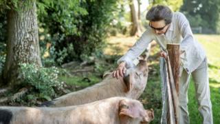 Princess Anne tends to pigs on her estate