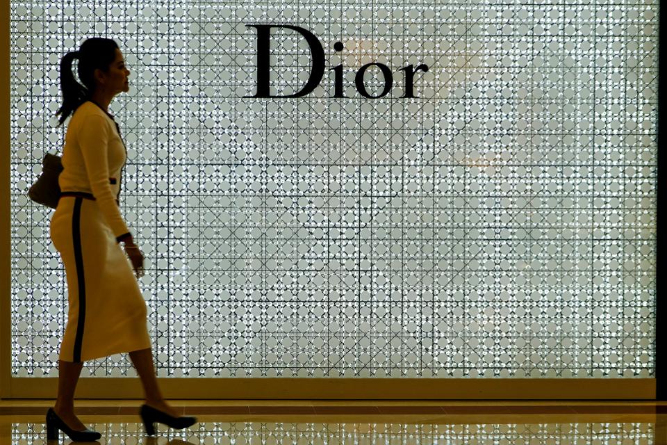 A lady seen walk in front of a Dior store...
