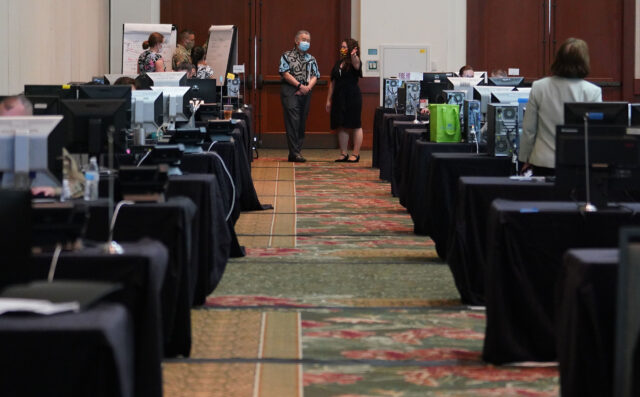 Emily Roberson, DOH Disease Investigation Branch Chief and Governor David Ige in a large room at the Hawaii Convention Center with banks of computers and contact tracing personnel. August 19, 2020