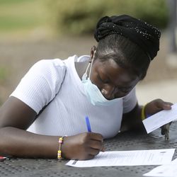 Debrah Tamari registers for eighth grade at Clayton Middle School at Park Place at City Centre Apartments in Salt Lake City on Tuesday, Aug. 25, 2020.