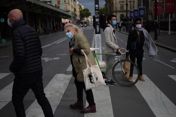 Pedestrians wearing masks Thursday in Paris, where police found nearly 100 bars and restaurants flouting coronavirus safety measures over the weekend.