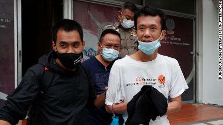 Thai pro-democracy activist Ekachai Hongkangwan (R) is escorted by police officers after being arrested, at Lat Phrao police station in Bangkok, on 16 October 2020. 