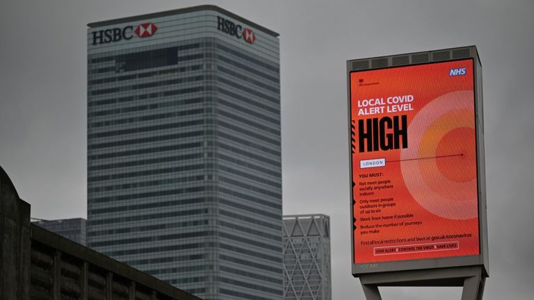 A sign displaying the Local Covid Alert Level as "HIGH" is pictured near Canary Wharf in east London, on October 17, 2020, as Londoners face more stringent novel coronavirus COVID-19 restrictions as the number of cases rises. - The government has announced that London has moved into tier two, the high alert level, of a three tier system of restrictions. (Photo by JUSTIN TALLIS / AFP) (Photo by JUSTIN TALLIS/AFP via Getty Images)
