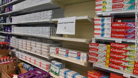 A sign is placed on partially empty shelves at a market, boycotting French goods in Kuwait City, Kuwait on October 24