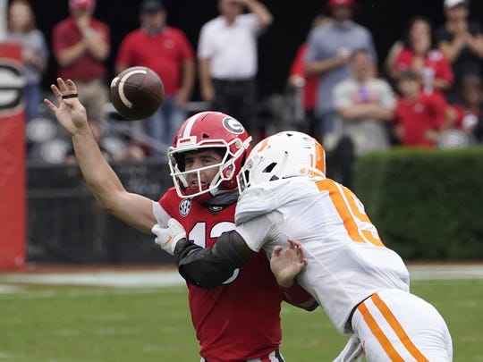 Georgia quarterback Stetson Bennett (13) is hit by Tennessee linebacker Morven Joseph (19) as he releases a pass in the first half of an NCAA college football game Saturday, Oct. 10, 2020, in Athens, Ga. (AP Photo/John Bazemore)