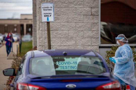 Registered nurse Erica Fairfield, right, works at the Hackley Community Care COVID-19 curbside testing site on Friday in Muskegon Heights, Mich.