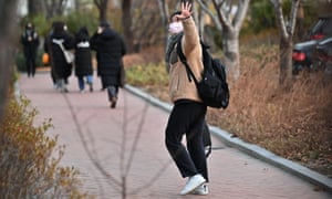 A student waves to her mother as she walks to an exam room to sit the annual College Scholastic Ability Test, a standardised exam for college entrance, at a high school in Seoul on 3 December 2020.