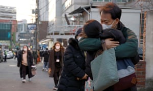 A parent hugs their child before they take the annual college entrance examinations amid the coronavirus pandemic in front of an exam hall in Seoul, South Korea, 3 December 2020.
