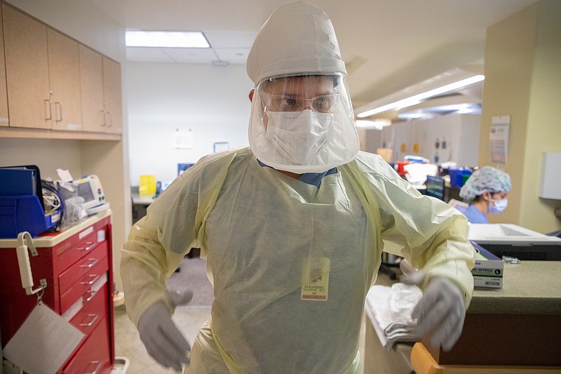 Dr. Alejandro Villegas prepares to enter a COVID-19 patient's room in the int...