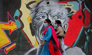 Women walk past a mural painting along a roadside in Bangalore, India, 9 January 2021.
