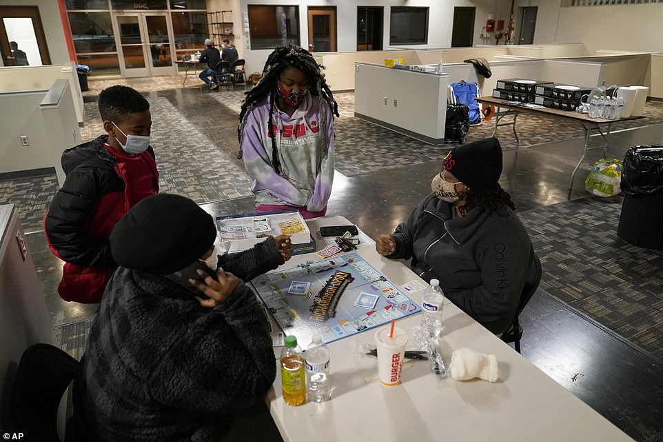 Richardson, Texas: Shaemiya Taylor, left front, and Marsha Williams, right front, play a board game as Jeremiah Murphy, left rear, and Khloee Williams, right rear, look on at a warming shelter Tuesday. In cooperation with the cities emergency management center, this location is one of seven that have opened in the city, offering those in need a place to keep warm