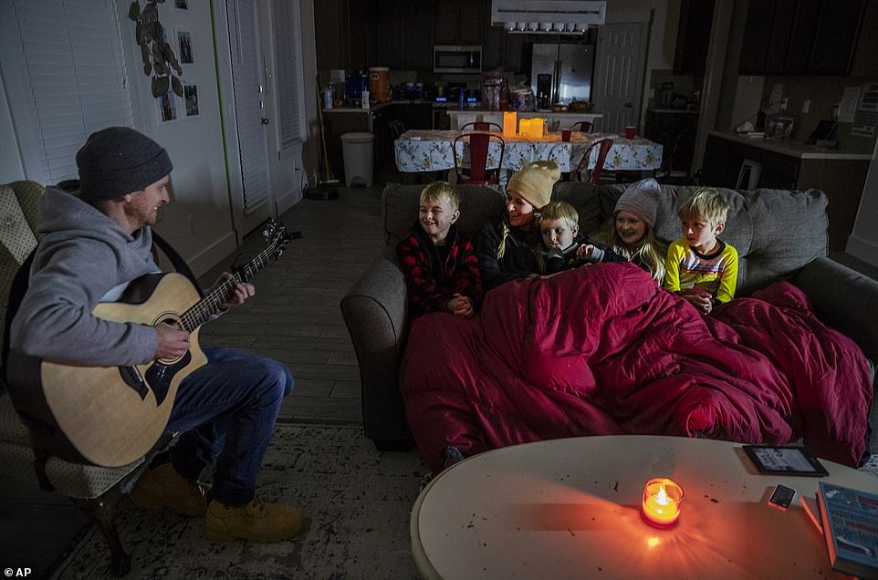 Pflugerville, Texas: Brett Archibad tries to entertain his family as they attempt to stay warm in their home Tuesday