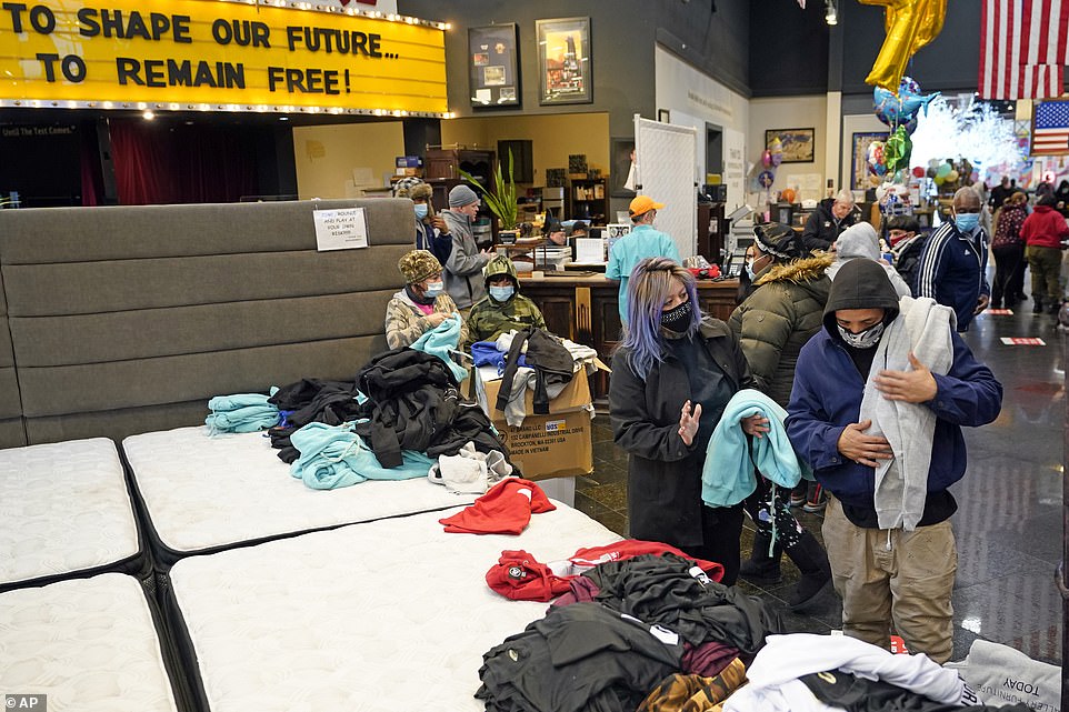Houston, Texas: People select shirts and sweatshirts being given away at a Gallery Furniture store after the owner opened his business as a shelter for those without power at their homes Tuesday