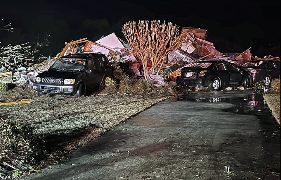 Damaged vehicles sit among debris after a deadly tornado tore through Brunswick County