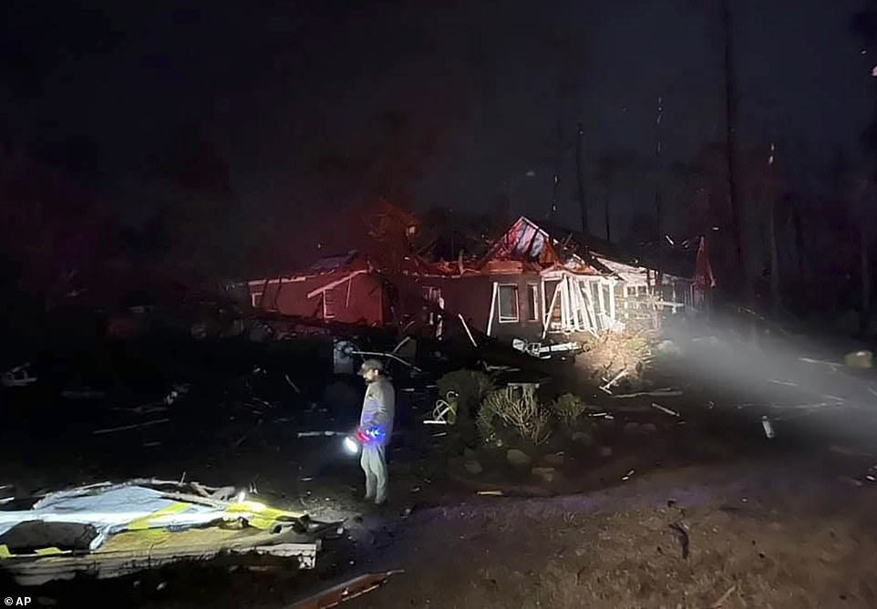 A man surveys the damage after a deadly tornado tore through Brunswick County, North Carolina just before midnight