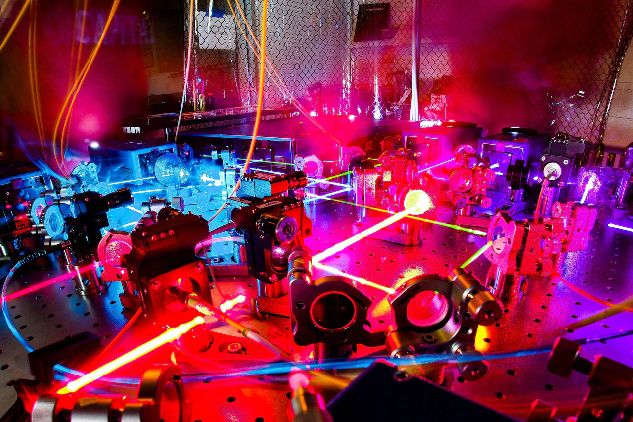 A large room filled with equipment is bathed in colorful lights.