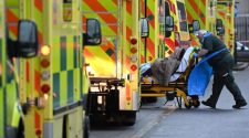 A paramedic is seen by a line of ambulances outside the Royal London Hospital in east London on January 5, 2021.