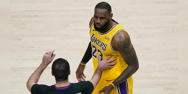 Los Angeles Lakers forward LeBron James (23) is restrained by an official as he reacts to a fan in the second half of an NBA basketball game against the Atlanta Hawks, Monday, Feb. 1, 2021, in Atlanta. (AP Photo/John Bazemore)