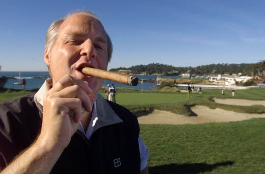 Talk show host Rush Limbaugh puffs on his Ashton VSG cigar while waiting to tee off from the fifth tee of the Pebble Beach Golf Links during third round play of the AT&T Pebble Beach National Pro-Am in Pebble Beach, Calif., Saturday Feb. 3, 2001. 