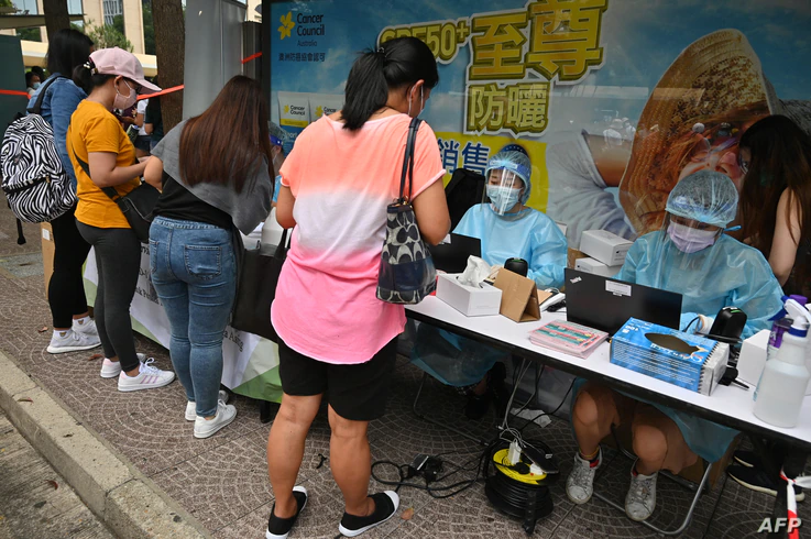 Migrant workers register for Covid-19 testing in the Central district of Hong Kong on May 1, 2021, after the government ordered…