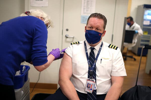 A United Airlines vaccine clinic at O’Hare Airport in Chicago. Employers are using on-site vaccinations to encourage workers to get shots.