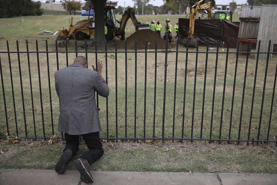 Rev Robert Turner, of Vernon AME Church, prays as crews search for remains at Oaklawn Cemetery in Tulsa, in October 2020.