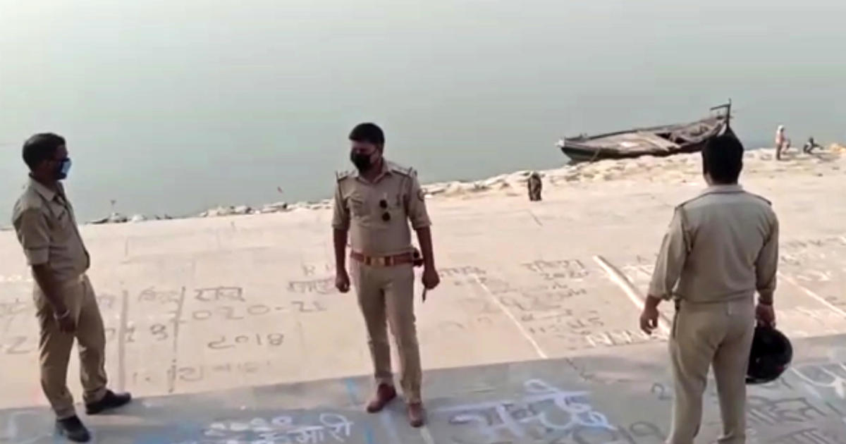 This frame grab from video provided by KK Productions shows police officials stand guard at the banks of the Ganges River, where several bodies were found, in Ghazipur district in Uttar Pradesh state, India, May 11, 2021. 
