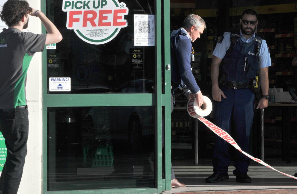 Police tape the front door of the supermarket after the stabbing attack today. Photo: Stephen Jaquiery