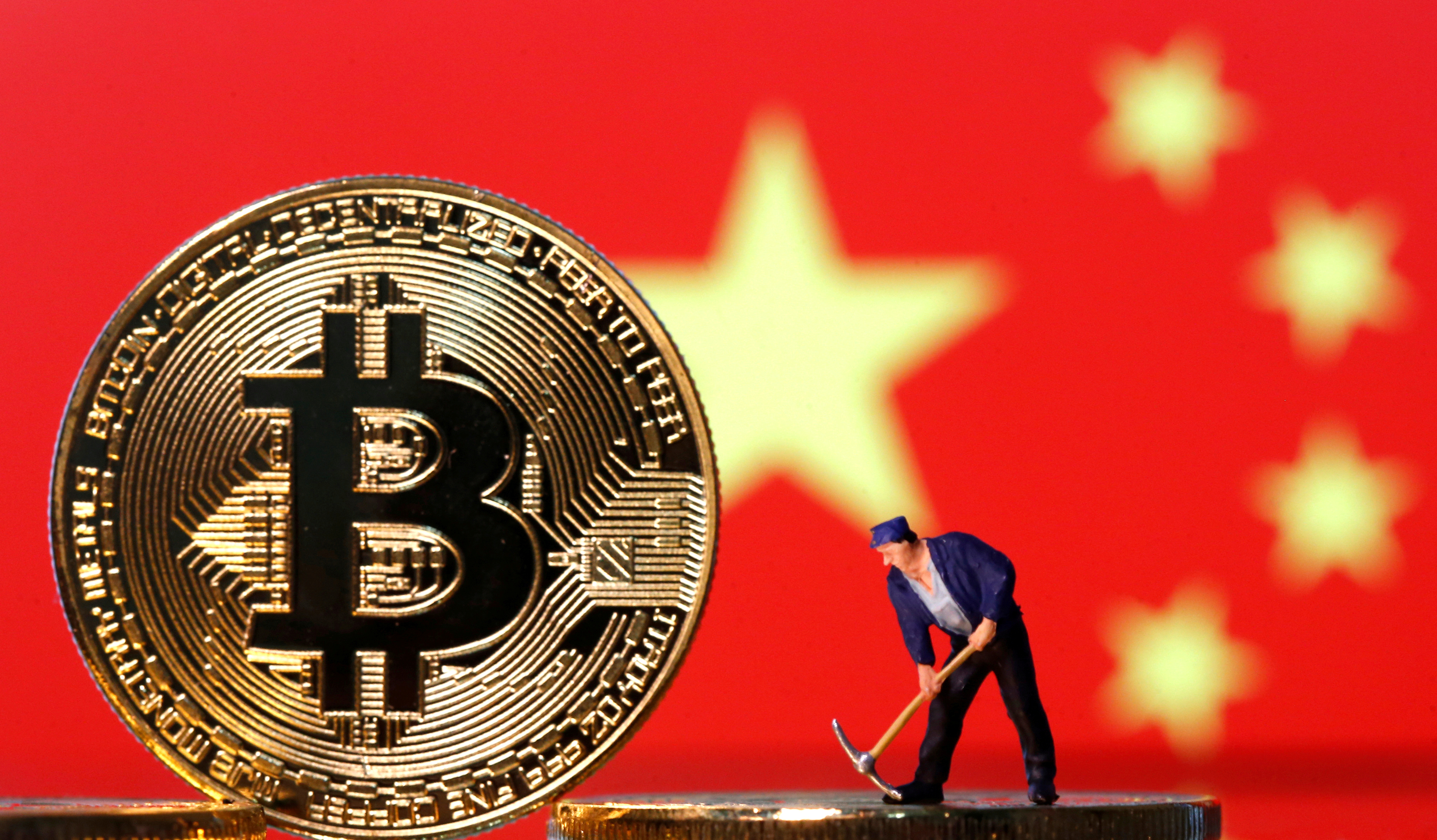 A small toy figurine is seen on representations of the Bitcoin virtual currency displayed in front of an image of China's flag in this illustration picture, April 9, 2019. REUTERS/Dado Ruvic/Illustration