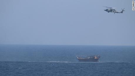 An SH-60 Sea Hawk helicopter assigned to the guided-missile cruiser USS Monterey flies above a stateless dhow interdicted with a shipment of illicit weapons in international waters of the North Arabian Sea on May 6, 2021.