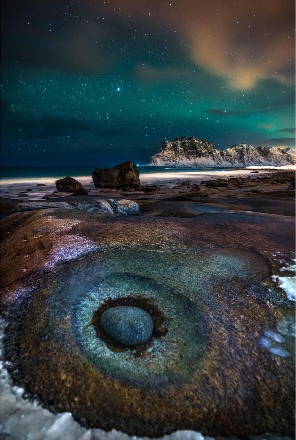 A beach at night with a star-filled sky above
