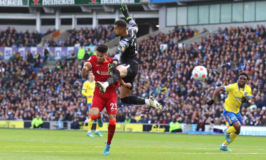 Luis Díaz collides with Brighton goalkeeper Robert Sánchez as he heads home the opening goal for Liverpool.