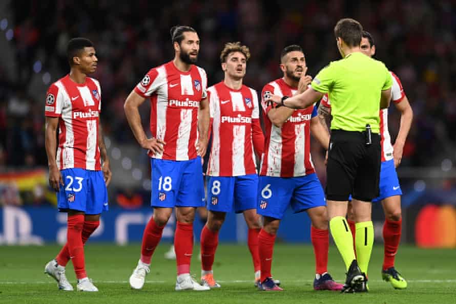 Referee Daniel Siebert interacts with Koke of Atletico Madrid and teammates.