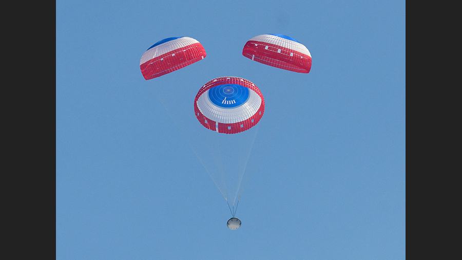 Boeing's Starliner spacecraft descends to Earth underneath parachutes for a landing in New Mexico completing the Orbital Flight Test-2 mission. Credit: NASA/Bill Ingalls