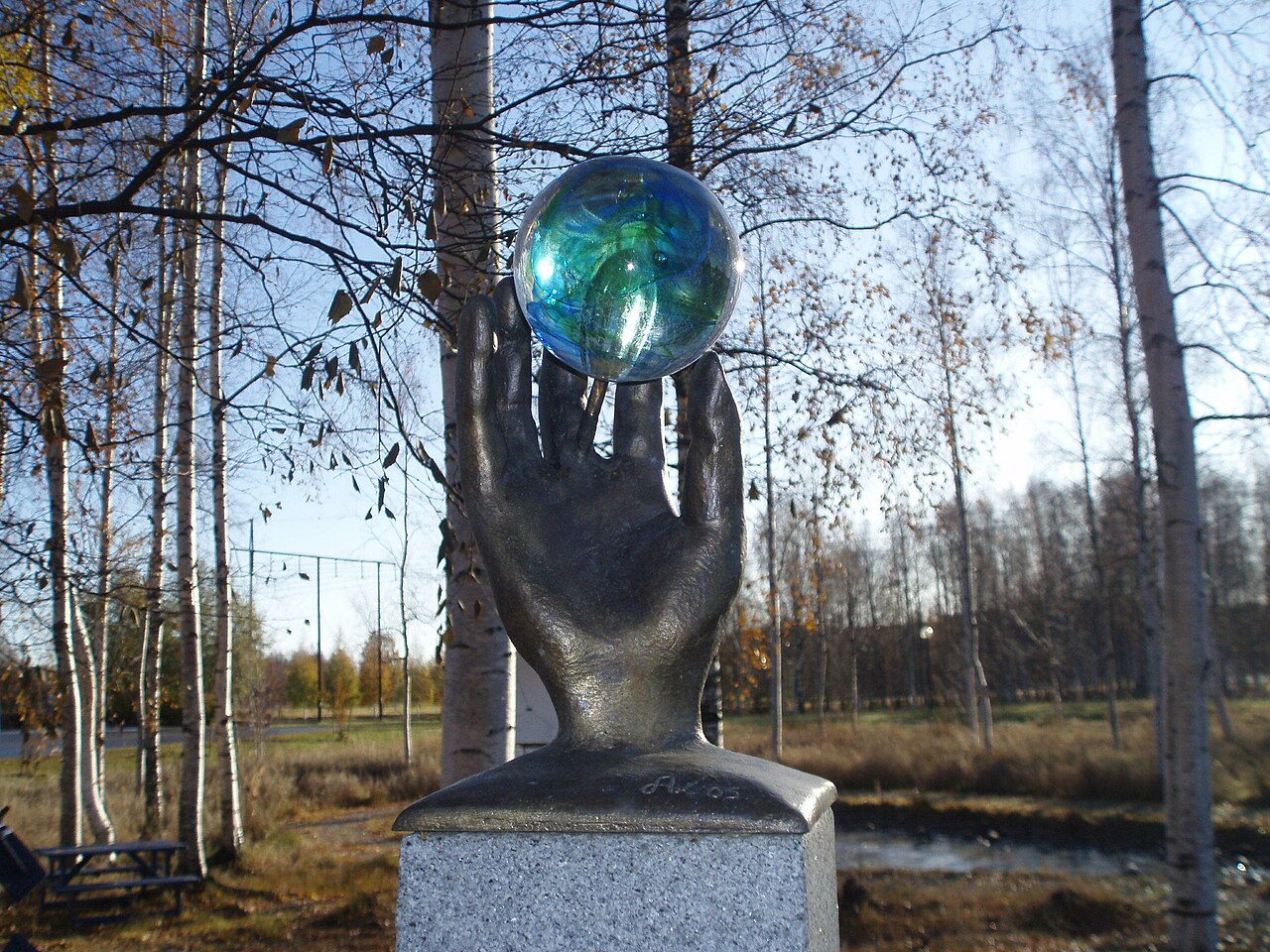 a statue of a hand with a blue ball in it.
